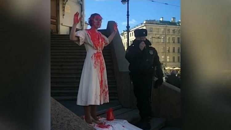 Una activista rusa se cumbre de sangre falsa para protestar contra la guerra