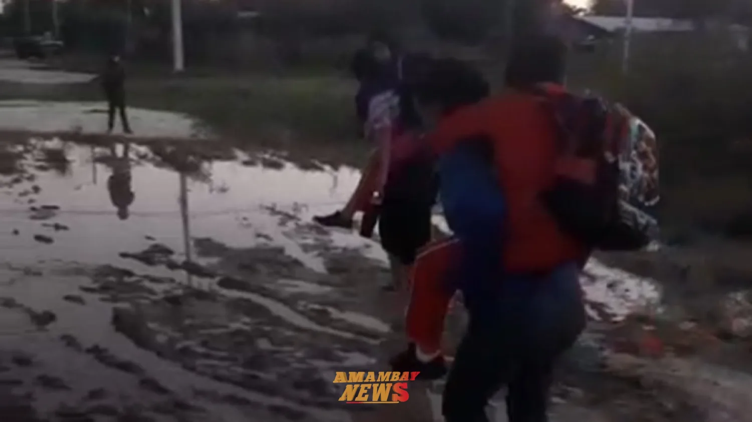 Madres cargan a sus hijos para cruzar camino inundado y llegar a la escuela en Puerto Casado